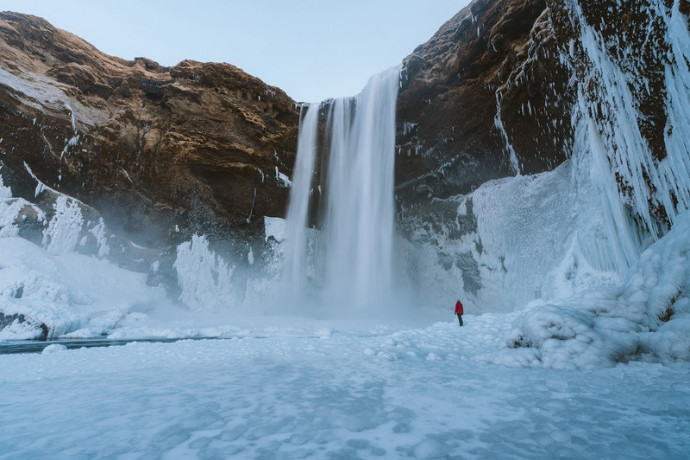 Skógafoss waterfall surrounded by ice and snow in winter, Iceland