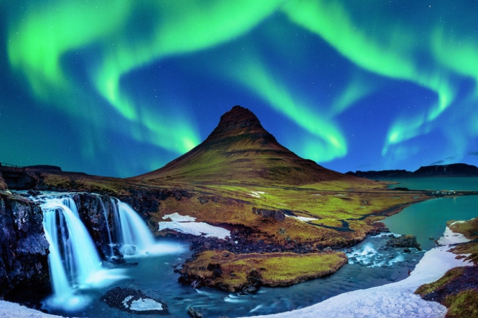 Northern Lights over Kirkjufell mountain and waterfall in Iceland in winter