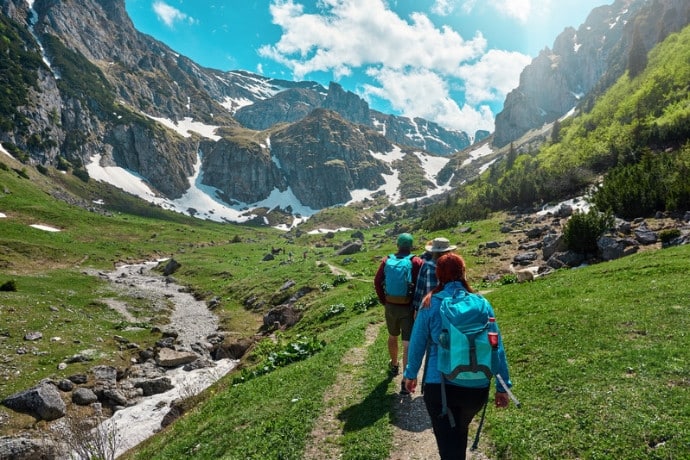 A small group of hikers walking together through an alpine valley